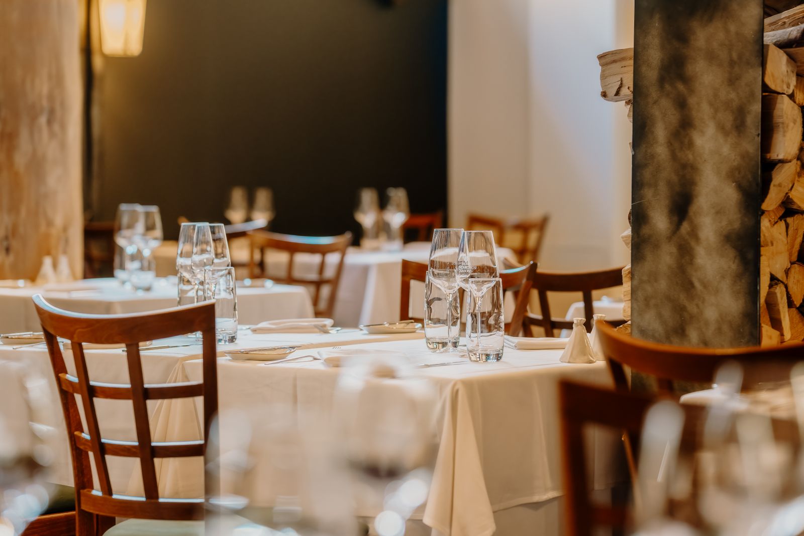 Intérieur de brasserie cosy — tables nappées et chaises en bois