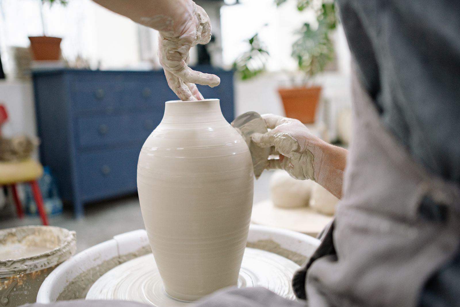 Atelier de poterie — artisan façonnant une pièce de céramique sur tour