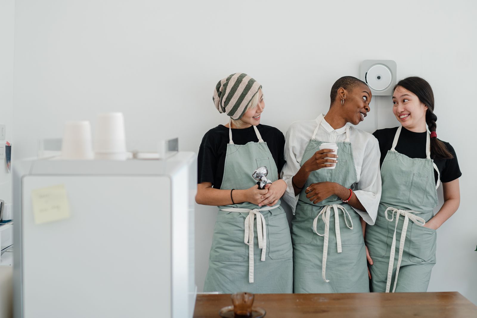 Équipe de serveuses souriantes en tablier dans un café